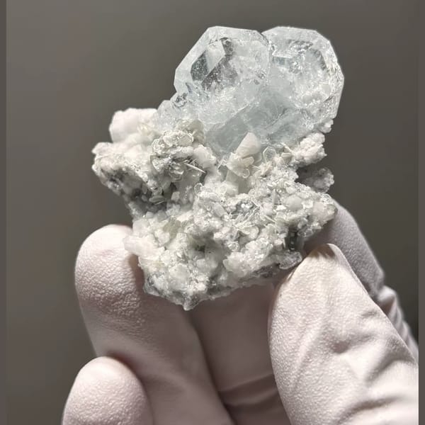 Pale blue Xuebaoding aquamarine on feldspar and mica matrix — complete view