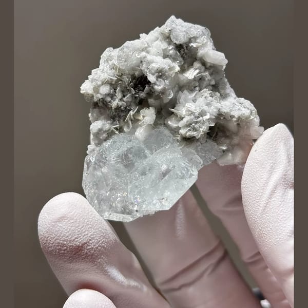 Pale blue Xuebaoding aquamarine on feldspar and mica matrix — detail view