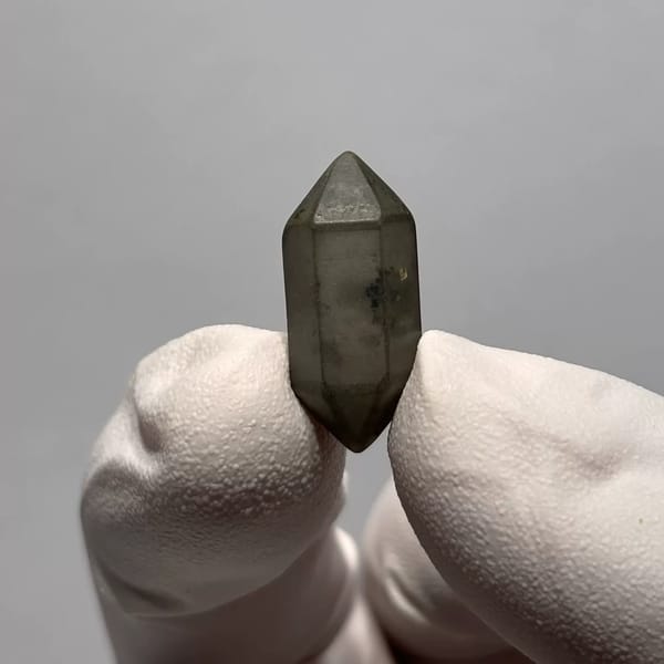Water-Worn Double-Terminated Quartz with Inclusions from Yunnan, China, held in a gloved hand, photo 1 of 3