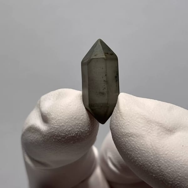 Water-Worn Double-Terminated Quartz with Inclusions from Yunnan, China, held in a gloved hand, photo 2 of 3