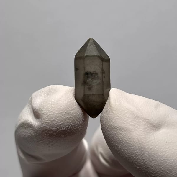 Water-Worn Double-Terminated Quartz with Inclusions from Yunnan, China, held in a gloved hand, photo 3 of 3