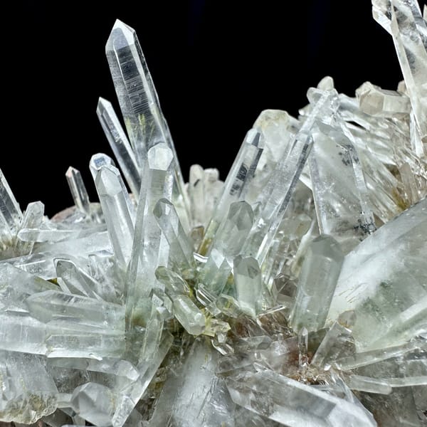 Radiating clear quartz needle cluster with green phantoms from Guangdong, China, close-up of the crystal faces