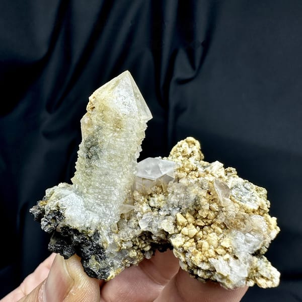 Skeletal quartz point with green phantom on calcite and dolomite matrix from Inner Mongolia, detail of the matrix contact