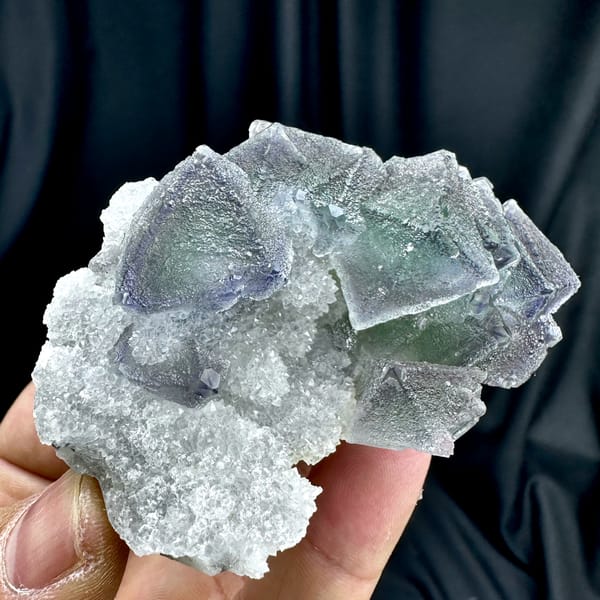 Row of purple and green zoned fluorite octahedra on quartz from Fujian, China, close-up of the crystal faces