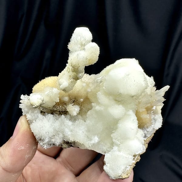 Snow-white aragonite tufts on yellow calcite from Guizhou, China, detail of the matrix contact