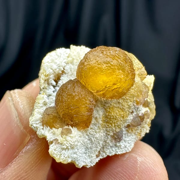 Two amber-yellow botryoidal fluorite balls on white quartz from Henan, China, reverse side