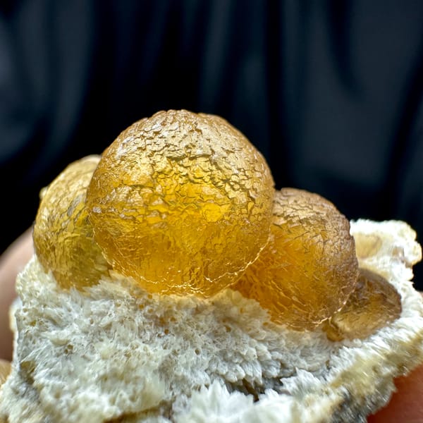 Two amber-yellow botryoidal fluorite balls on white quartz from Henan, China, top view