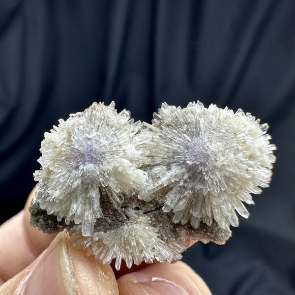 Purple-cored creedite needle sprays on matrix from Guizhou, China, detail of the matrix contact