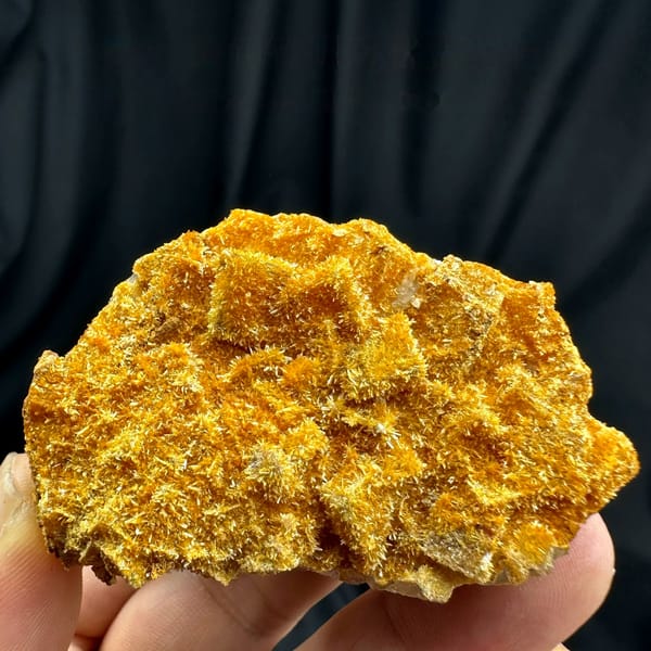 Fluorite cubes coated in orange jarosite crust from Guizhou, China, held in hand