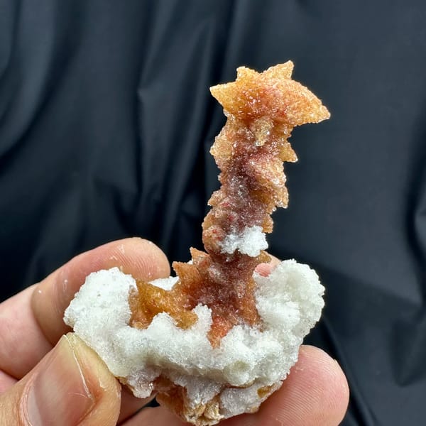 Rust-red double-terminated calcite crystal enclosed in white gypsum from Guizhou, China, top view