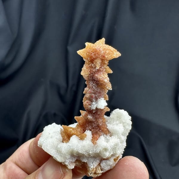 Rust-red double-terminated calcite crystal enclosed in white gypsum from Guizhou, China, detail of the matrix contact