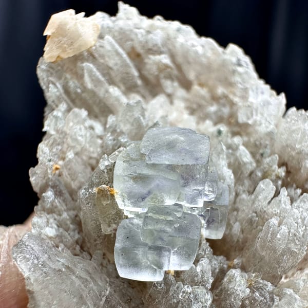Pale blue-green stepped fluorite cube on feldspar matrix from Yunxiao, Fujian, China, close-up of the crystal faces