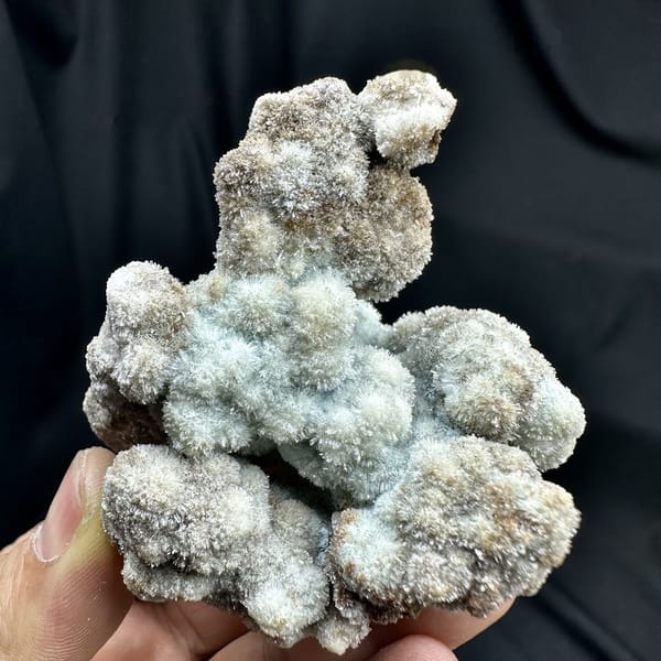 Blue-grey botryoidal creedite floater from Guizhou, China, detail of the matrix contact
