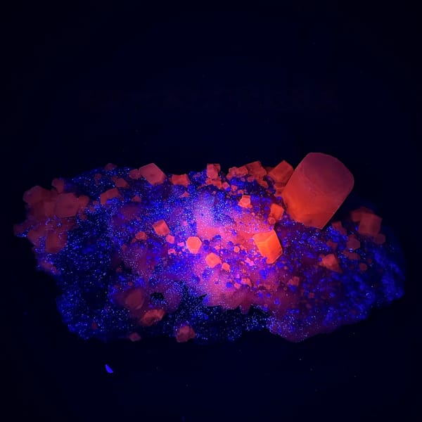 Large quartz druse plate with hexagonal calcite prism from Fujian, China, held in two hands, second angle