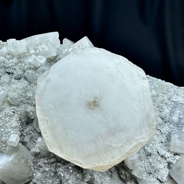 Large quartz druse plate with hexagonal calcite prism from Fujian, China, held in two hands, close-up of the crystal faces