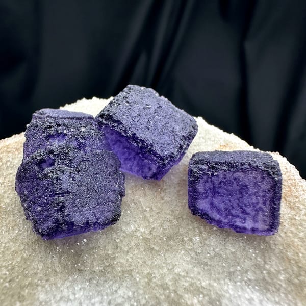 Four deep purple fluorite cubes on cream quartz matrix from Guizhou, China, second angle