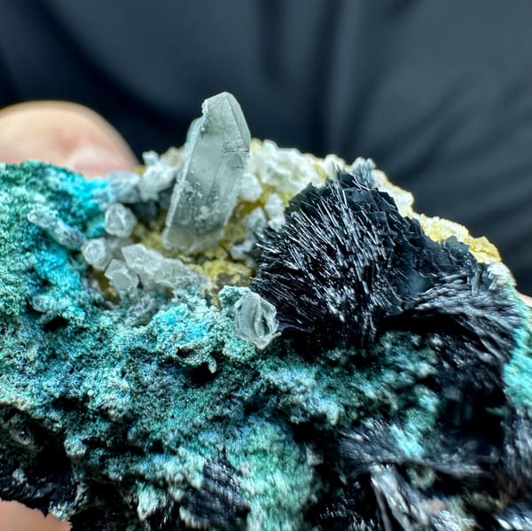 Green malachite with black specular hematite rosettes and quartz from Inner Mongolia, China, close-up of the crystal faces