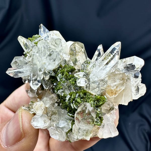 Transparent quartz cluster with green epidote from Sichuan, China, close-up of the crystal faces
