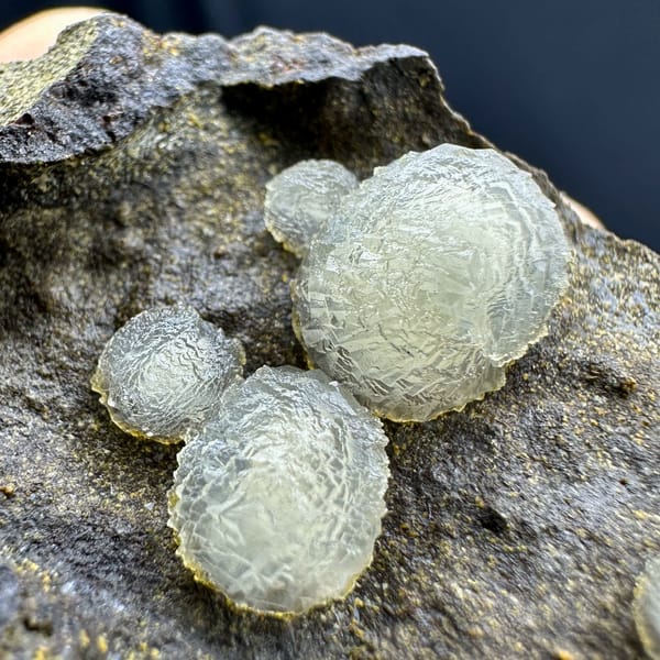 Cream-white botryoidal calcite balls on dark rock from Zhejiang, China, second angle