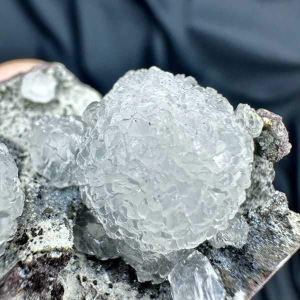 Two white botryoidal calcite spheres on grey matrix from Zhejiang, China, close-up of the crystal faces