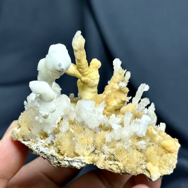 White aragonite spires on golden aragonite base from Guizhou, China, close-up of the crystal faces