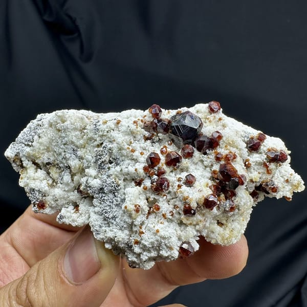 Wine-red garnet crystals with hyalite opal on feldspar from Yunxiao, Fujian, China, detail of the matrix contact