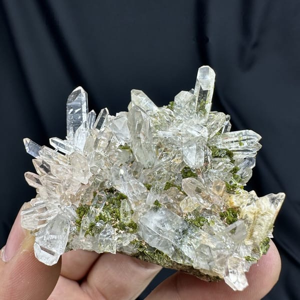 Clear quartz point cluster over green epidote from Sichuan, China, detail of the matrix contact