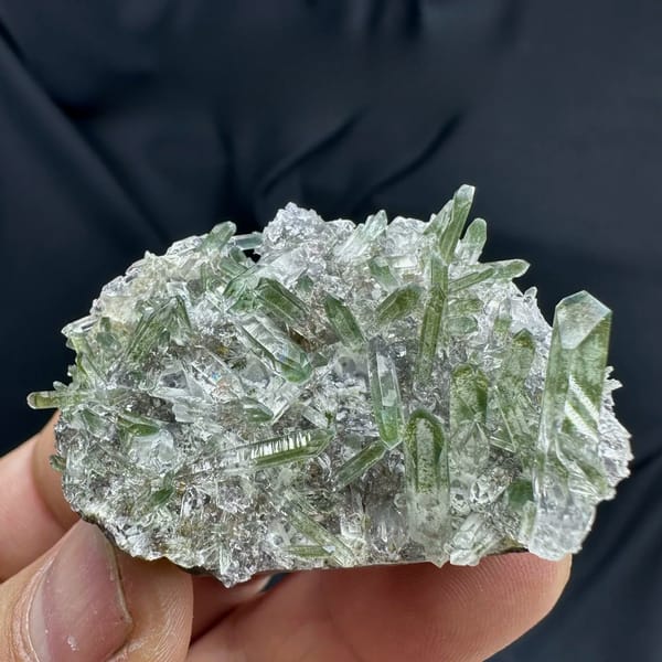 Green phantom quartz needle cluster from Sichuan, China, held in hand