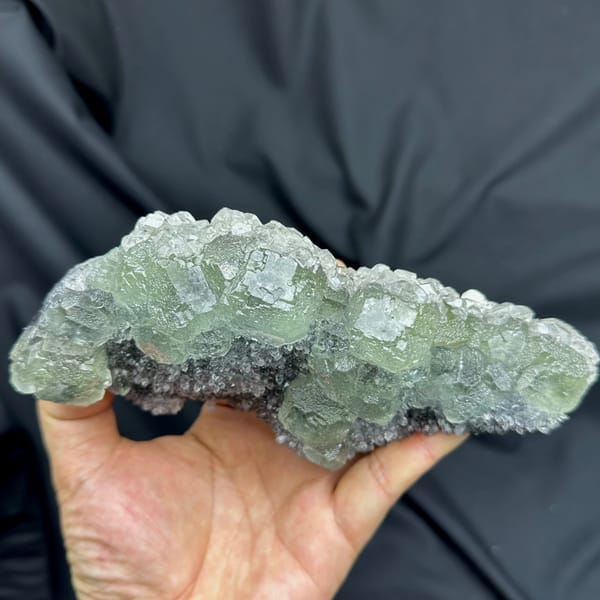 Long plate of pale green fluorite over grey quartz from Fujian, China, close-up of the crystal faces