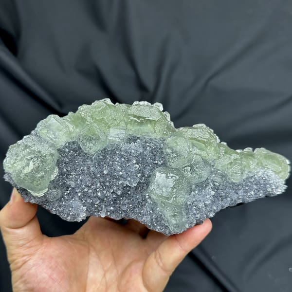 Long plate of pale green fluorite over grey quartz from Fujian, China, top view