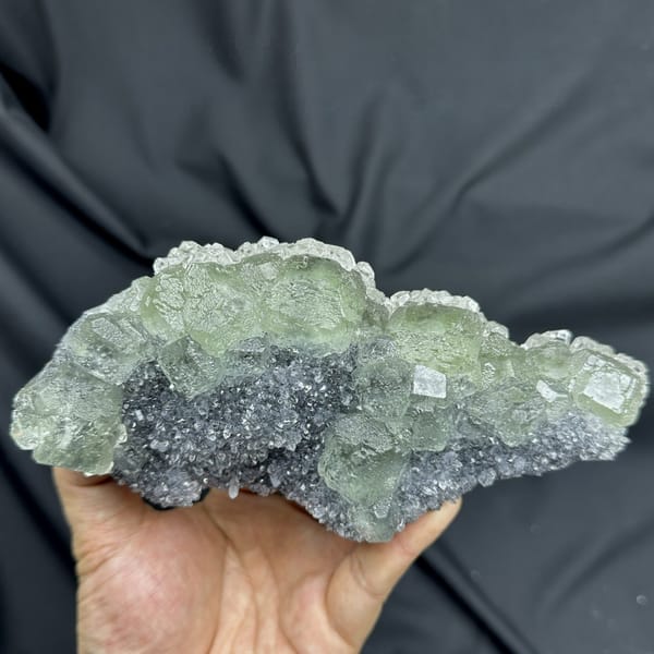 Long plate of pale green fluorite over grey quartz from Fujian, China, detail of the matrix contact