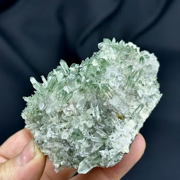 Cluster of green phantom quartz points from Sichuan, China, held in hand