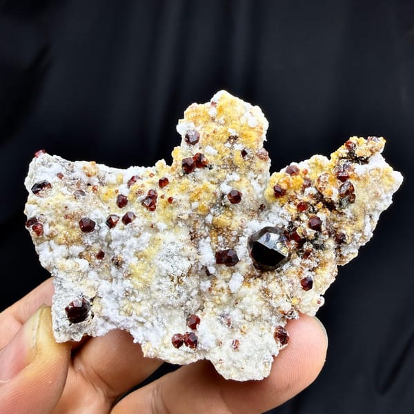 Large dark-red garnet crystals with hyalite opal on feldspar from Yunxiao, Fujian, China, detail of the matrix contact