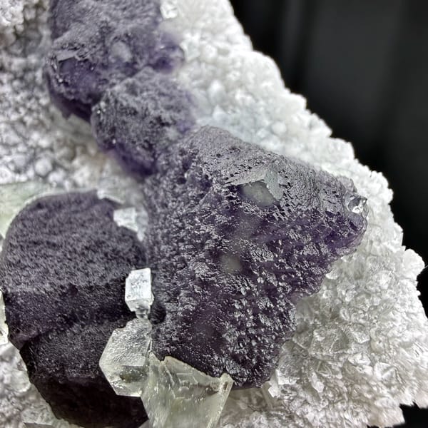 Muted purple recrystallised fluorite balls on white druse from Fujian, China, reverse side