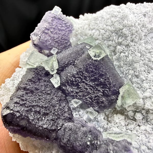 Muted purple recrystallised fluorite balls on white druse from Fujian, China, top view