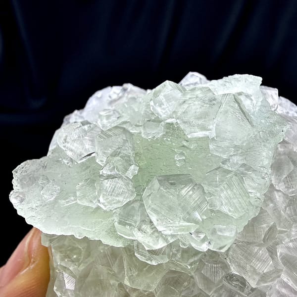 Green fluorite floater overgrown with clear calcite from Fujian, China, close-up of the crystal faces
