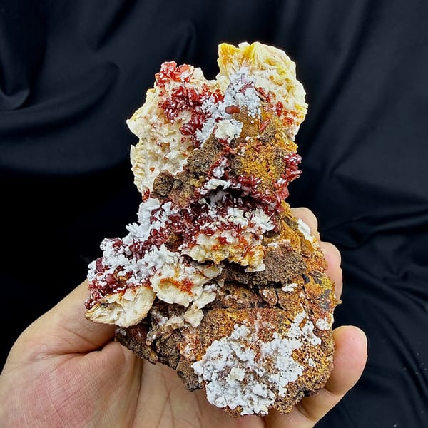 Red vanadinite crystals on brown baryte with white aragonite from Morocco, close-up of the crystal faces