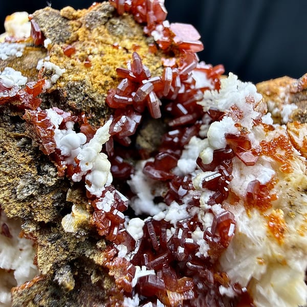 Red vanadinite crystals on brown baryte with white aragonite from Morocco, top view