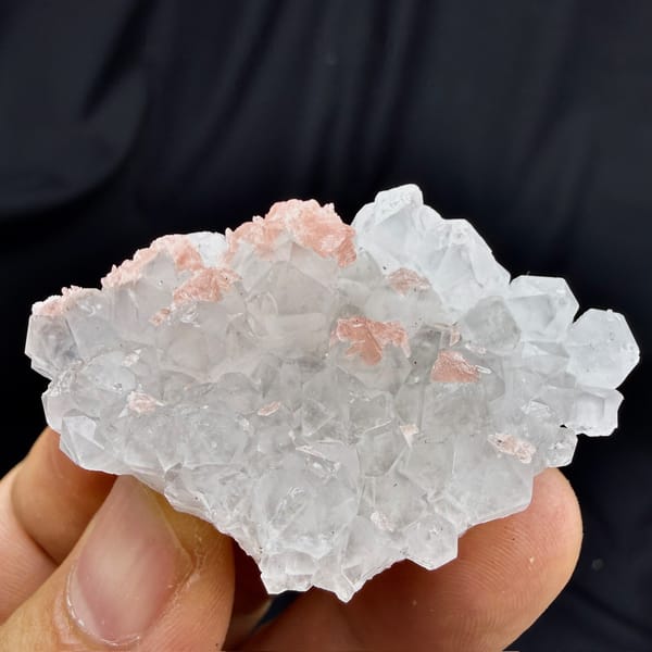 Pink rhodochrosite under frosted quartz crystals from Wuzhou, Guangxi, China, detail of the matrix contact