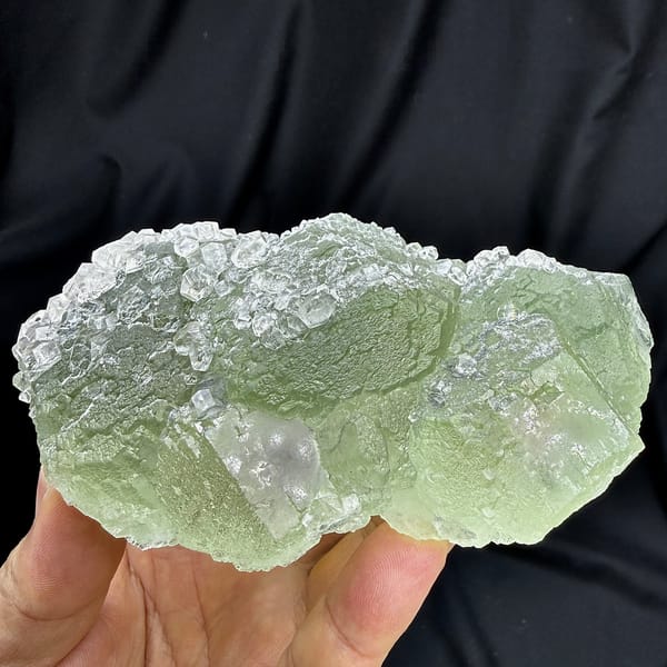 Pale green fluorite floater with clear calcite crystals from Fujian, China, detail of the matrix contact