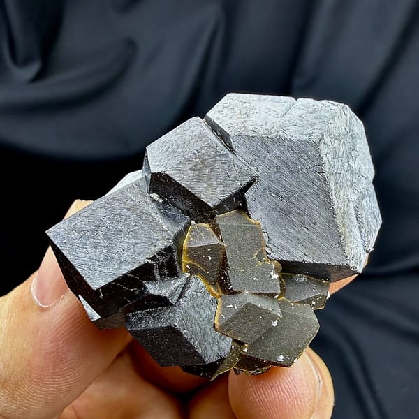 Black magnetite dodecahedral crystals with garnet from Inner Mongolia, China, close-up of the crystal faces