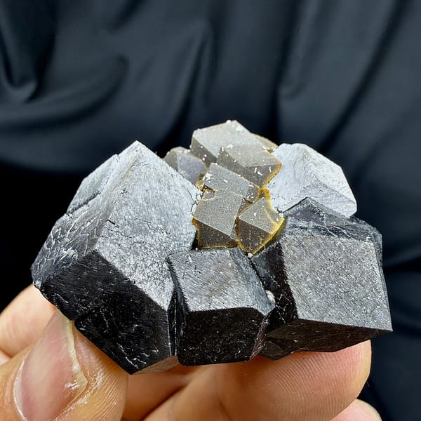 Black magnetite dodecahedral crystals with garnet from Inner Mongolia, China, detail of the matrix contact