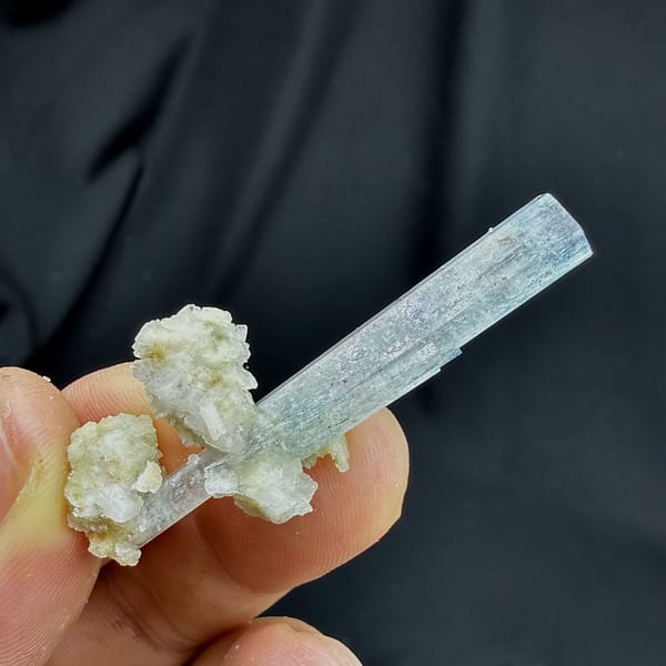 Sky-blue aquamarine prism standing on white feldspar from Namibia, top view
