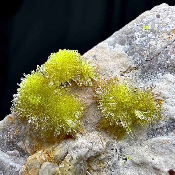 Lime-green creedite needle balls on pale matrix from Guizhou, China, close-up of the crystal faces