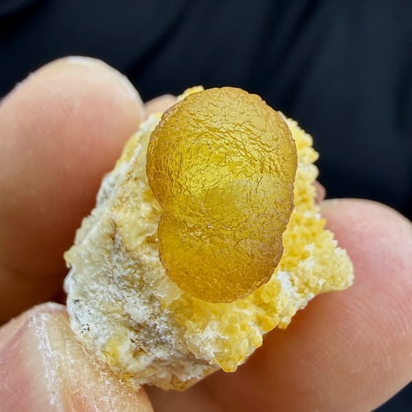 Golden-yellow botryoidal fluorite ball on white quartz from Henan, China, close-up of the crystal faces