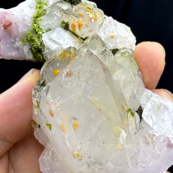 Milky garden quartz crystals with green epidote from Sichuan, China, close-up of the crystal faces