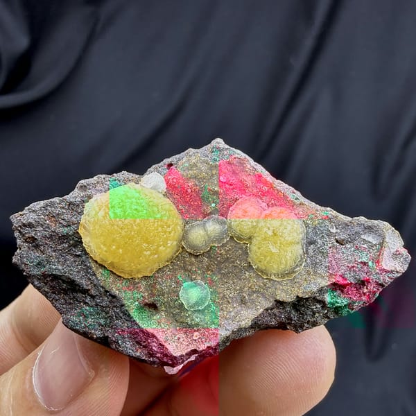 Egg-yolk yellow botryoidal calcite balls on dark matrix from Zhejiang, China, detail of the matrix contact