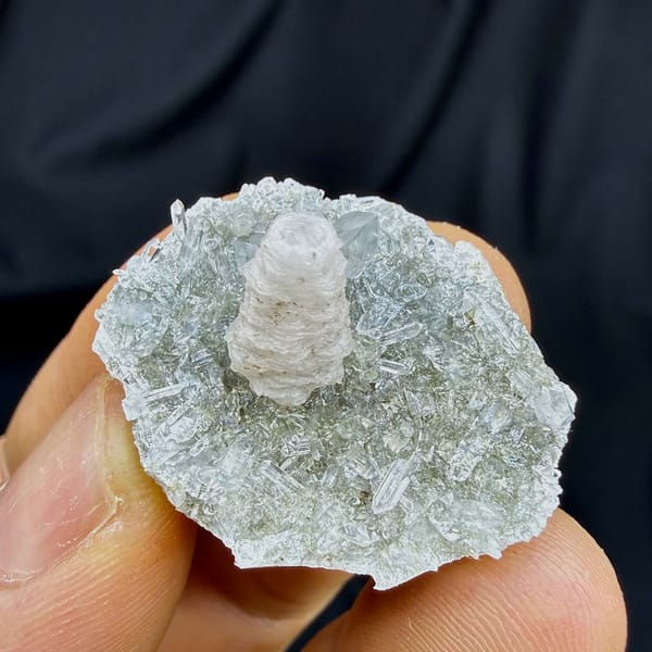 Stacked coin-shaped calcite tower on clear quartz needles from Fujian, China, reverse side