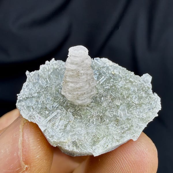 Stacked coin-shaped calcite tower on clear quartz needles from Fujian, China, detail of the matrix contact