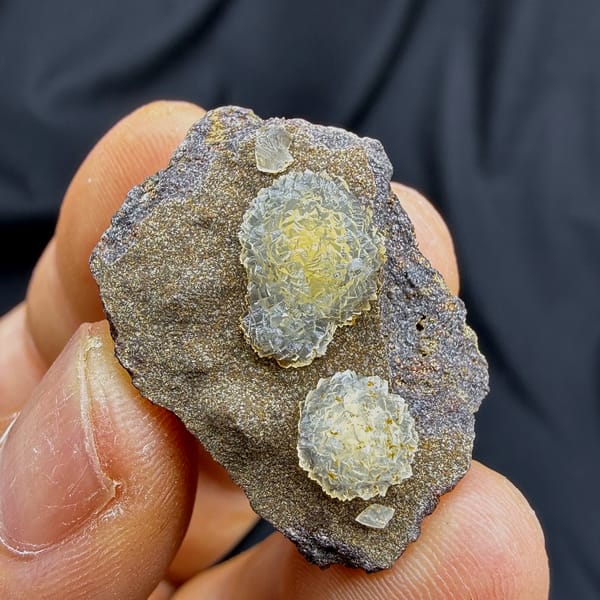 Two yellow soft-centred botryoidal calcite balls on brown matrix from Zhejiang, China, close-up of the crystal faces